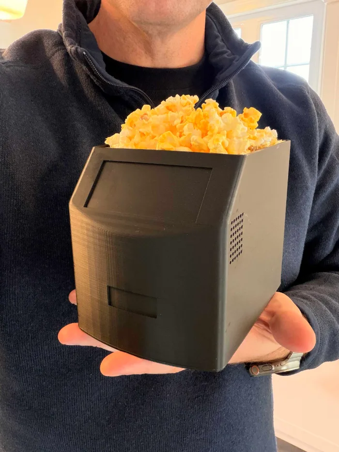 Edison Popcorn held in two hands and filled to the top with cheddar popcorn